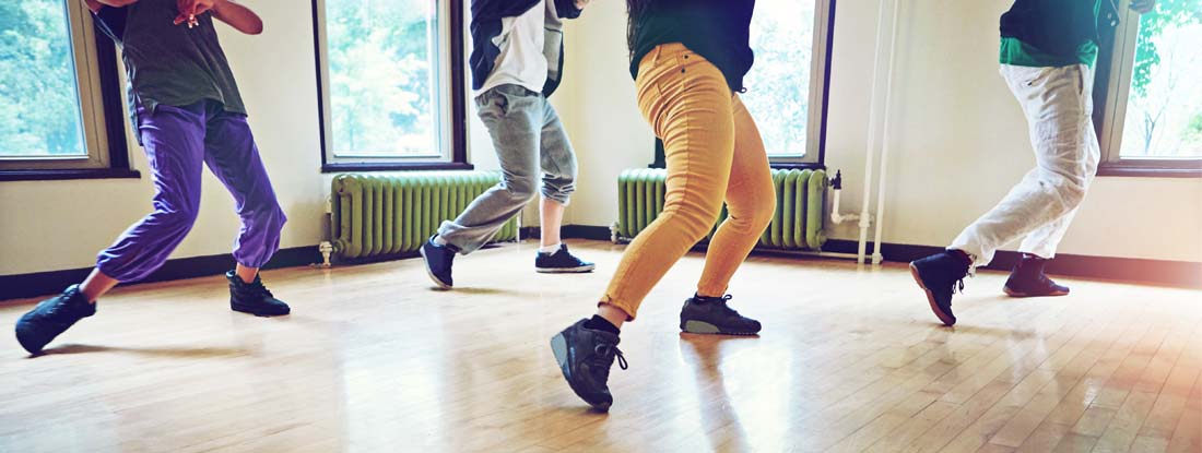 Group of people dancing together in a studio. Find Dance Studio Insurance.