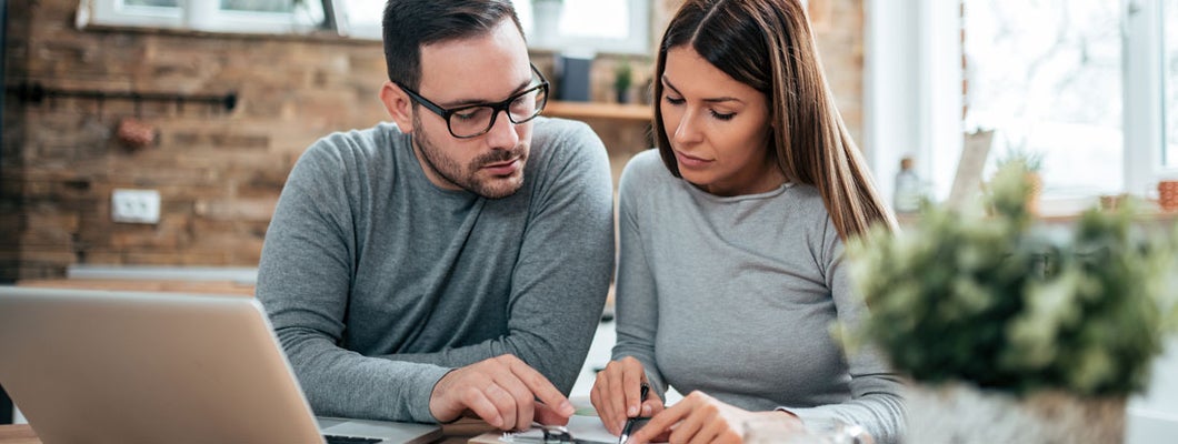 Couple doing finances at home. Saving Money on Insurance.