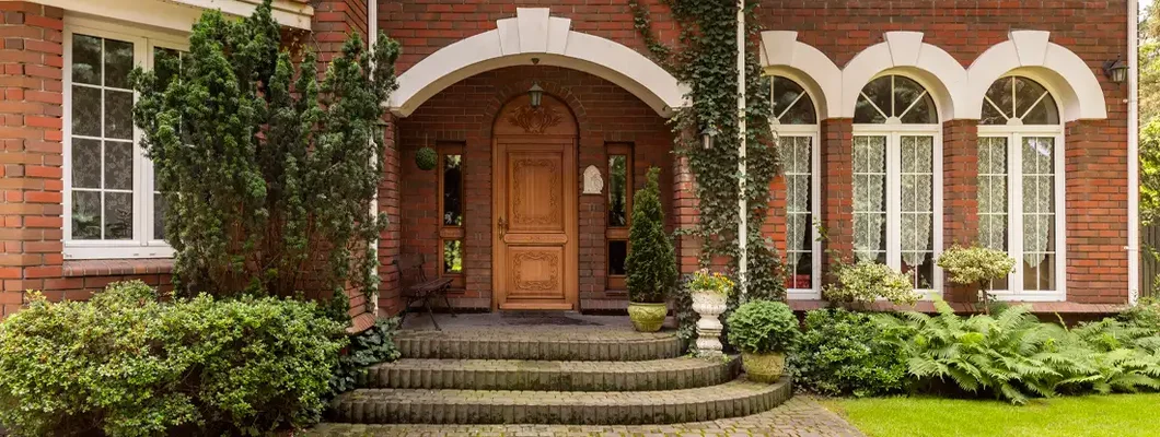 Cobbled path and steps leading to a stylish entryway in a red brick mansion. How to Find the Best Homeowners Insurance in Mt. Lebanon, Pennsylvania.