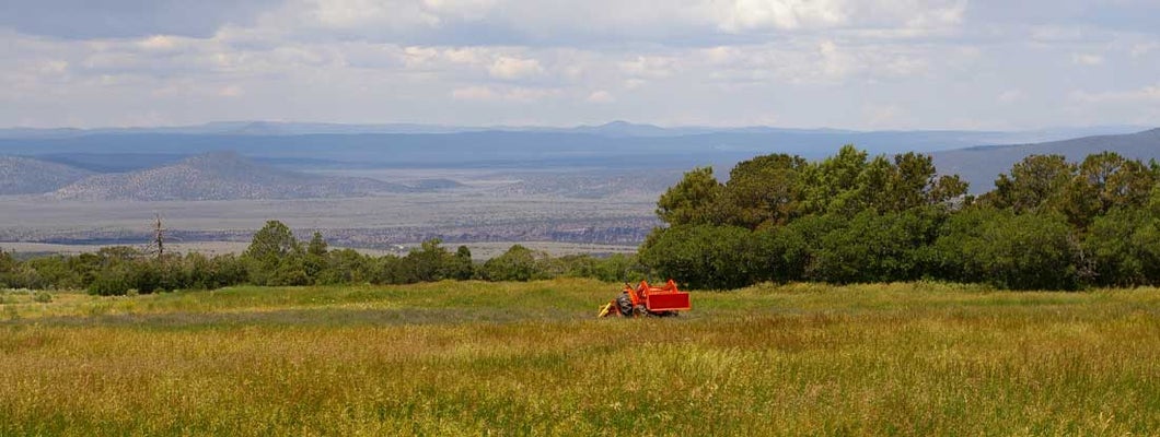 Red tractor on farmland. New Mexico State Laws and Regs.