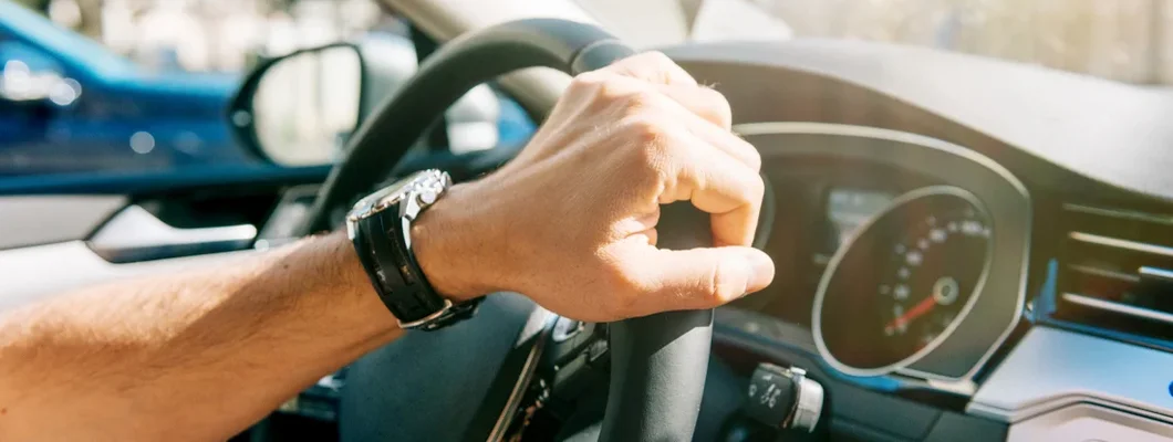 Man driving modern car in summer and turning steering wheel. How to Find the Best Car Insurance Coverage in North Liberty, Iowa.