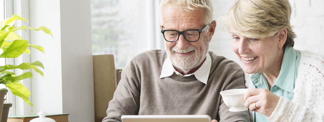 Senior Adult Couple using Digital Tablet. Variable Annuity Vs. Fixed.