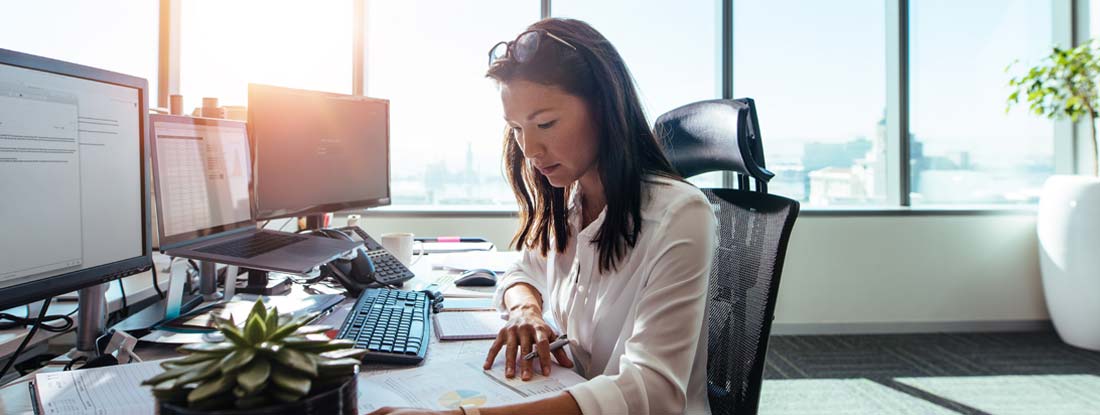 Woman entrepreneur at work in office. How to apply for workers compensation.