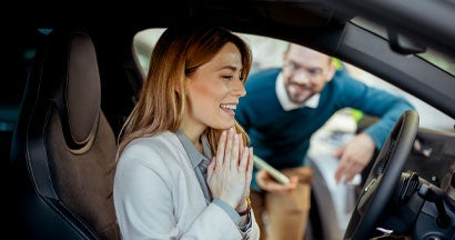 Woman sitting at the wheel of new car doing test-drive. Don't Skip the Inspection When Buying a Used Car. 