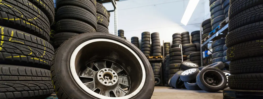 Close-up of tire against stacks in illuminated store. What are Chop Shops? What Do Chop Shops Do and Why?