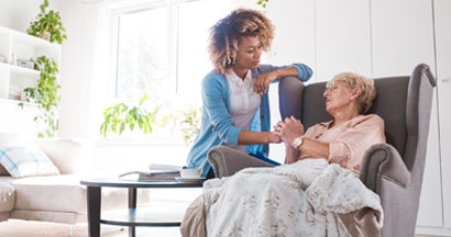 Home nurse taking care of an eldery lady. Traditional Long Term Care Insurance Coverages.