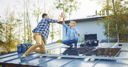 Father and Son Installing Solar Panels to a Metal Basis with a Drill. Eco friendly things you can do for your home.