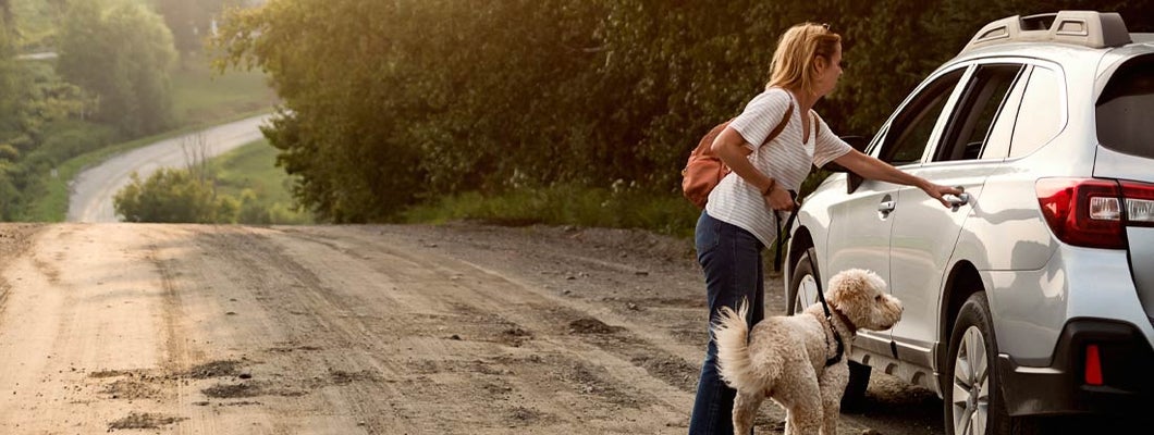 Woman going back to car after a walk with dog. Find Greensboro North Carolina car insurance.