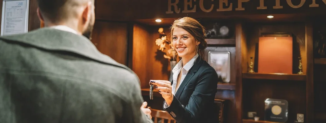 Receptionist giving keys to hotel guest. How to Find the Best Business Insurance in Branson, Missouri.
