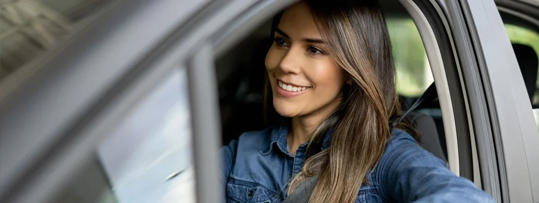 Woman at a showroom going for a test drive in a car. How to Find the Best Car Insurance in Herndon, VA. 
