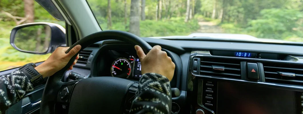 Driving car on road in nature. Car Insurance in Farmington, Utah.