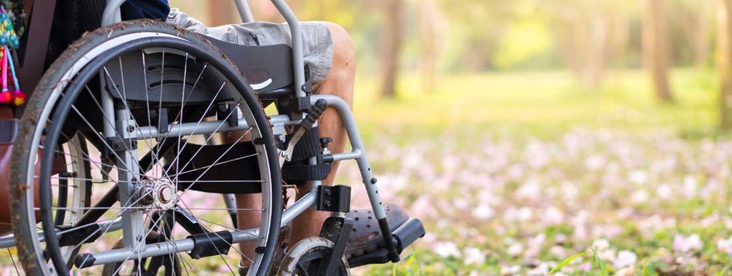 Senior on wheelchair in garden. Find disability income insurance benefits.