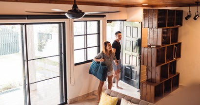 Young couple entering their house rented for vacation. Find Airbnb Landlord Insurance. 