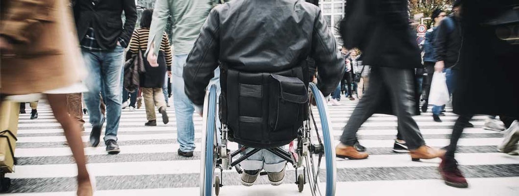 Man in Wheelchair on city street. Find the best individual long term disability insurance.
