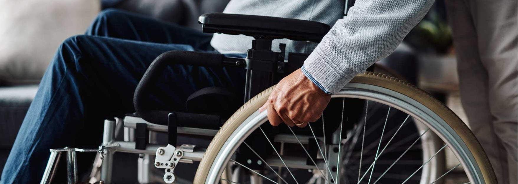 Man moving in his wheelchair  at home during the day. Find disability insurance.