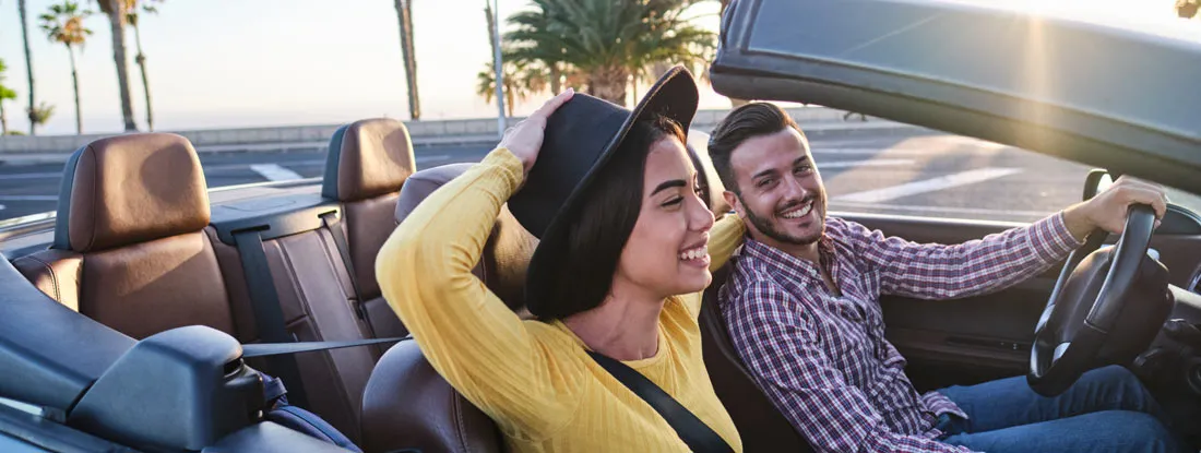Couple driving in Miami, Florida in convertible. Find Florida Car Insurance.