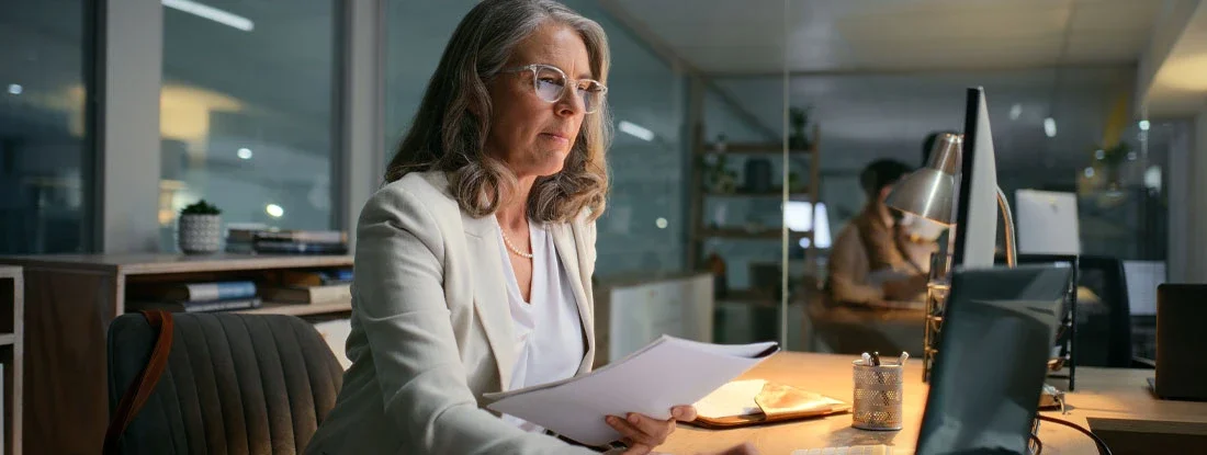 Woman sending financial email to client at night. 1035 Exchange life insurance.