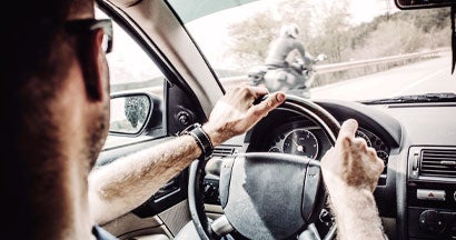 Man driving his Car with motorcycle overtaking. Motorcyclists: 8 Tips to Reduce Your Risk of Being Hit by a Car.