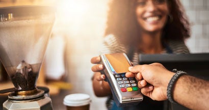 Closeup shot of a customer making a credit card payment in a cafe. Tips to boost POS security for small business owners. 