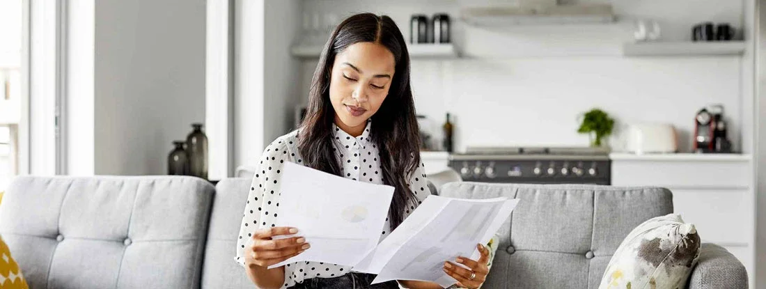 Female analyzing financial bills at home. Can I Use My Own Insurance Instead of Workers' Comp?