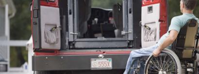 man in wheelchair looking at the chair lift in a van.