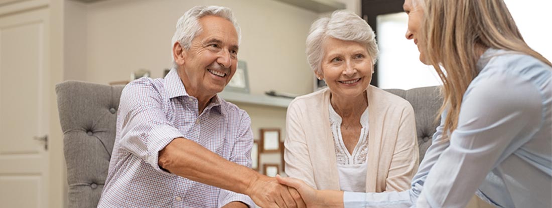 Senior couple shaking hands with financial advisor to discuss annuities. Variable Annuities FAQs.