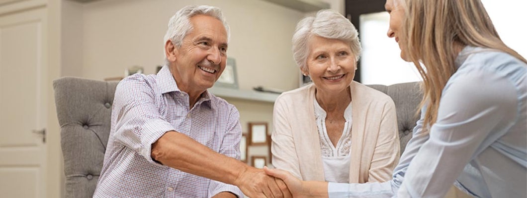 Senior couple shaking hands with financial advisor to discuss annuities. Variable Annuities FAQs.