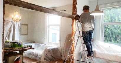 Man removing a metal beam during home renovation. If I Renovate My Home In New Jersey, Should I Call My Insurance Agent?
