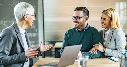 Happy couple talking to their insurance agent in the office. Your free guide to all the insurance that matters.