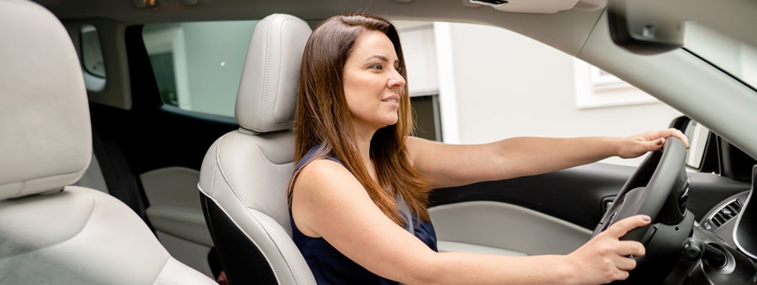 Woman sitting in the driver's seat of an SUV. Find Prairie Village, Kansas car insurance.