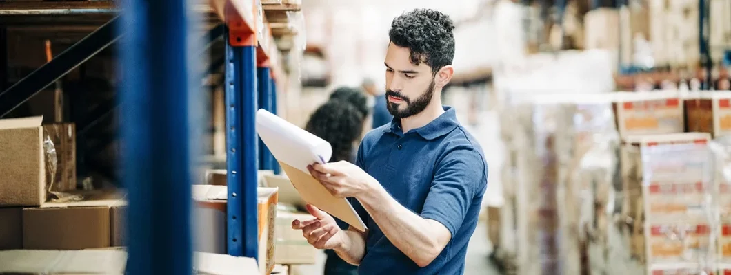 Man working in large warehouse taking inventory. Sanford, Maine Business Insurance. 