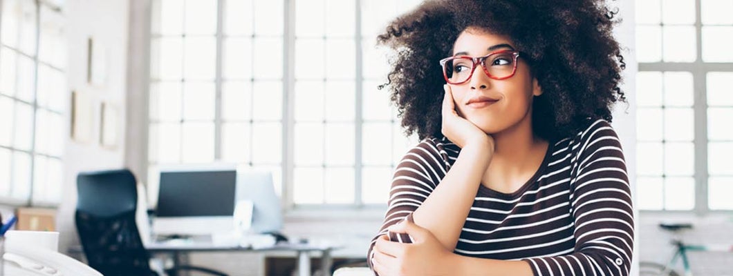 Cheerful young entrepreneur sitting on desk