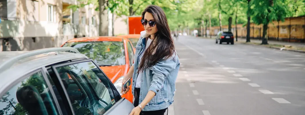 Young woman grabbing items from backseat of car. Find Apex, North Carolina car insurance.