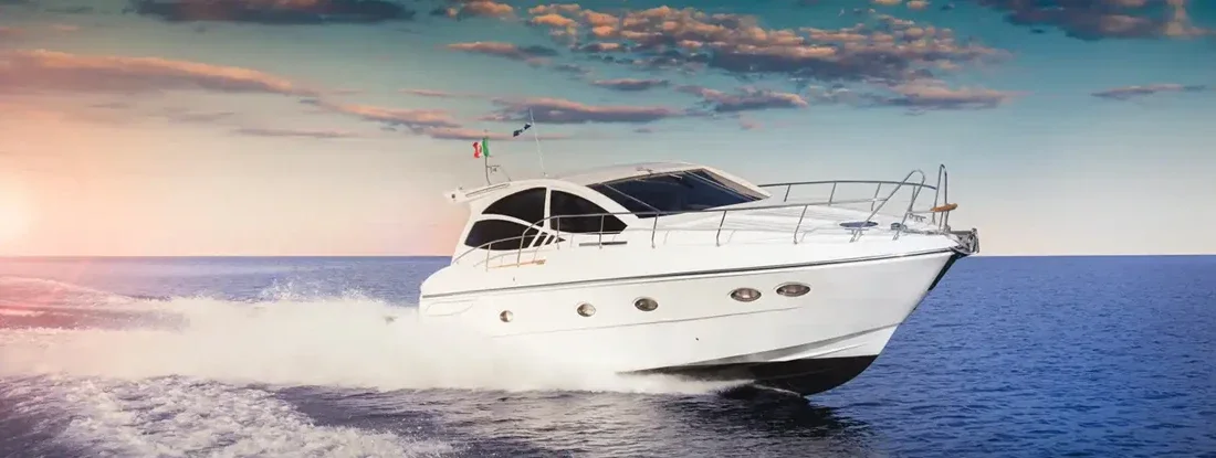 Luxurious motor boat sailing the sea at sunset. Best Boat Insurance Companies.