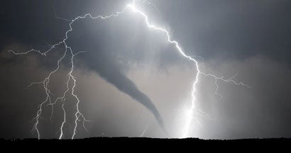 A powerful thunderstorm producing a tornado and lightning. 10 Key Safety Tips to Help You Get Through Tornado Season in Illinois. 