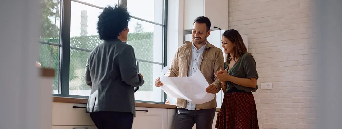 Real estate agent and a couple in the kitchen of a new house. How to Purchase a Home: A Step-by-Step Guide.