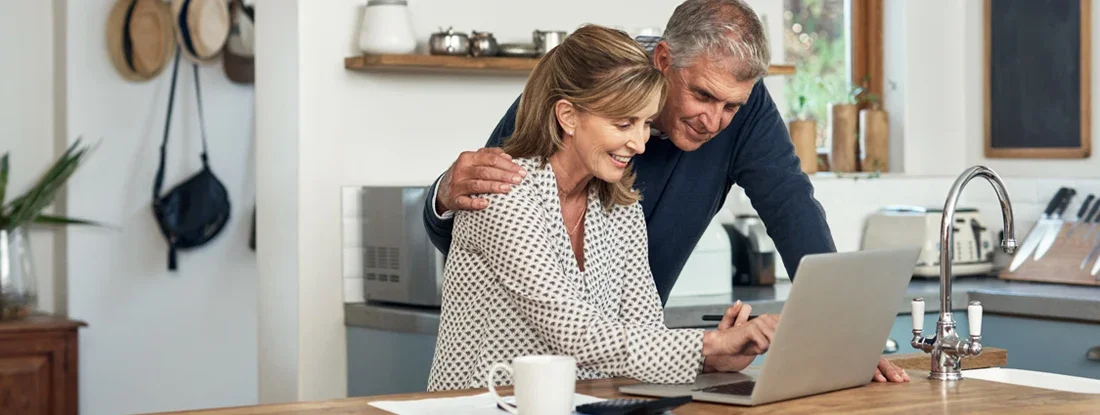 A senior couple researching car insurance using a laptop at home. How to shop for car insurance.