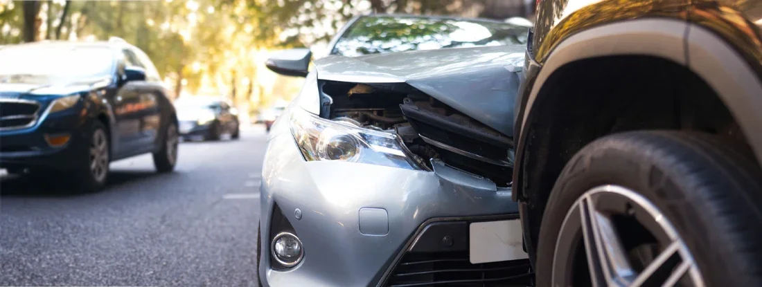 Two damaged vehicles in car accident after collision on city street. Find Collision Insurance.