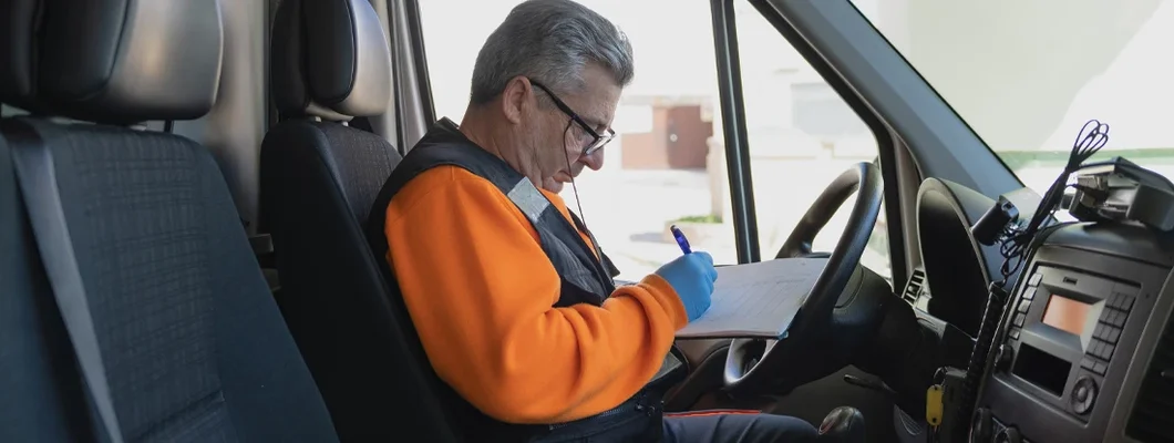 Paramedic writing on a paper in a work van. Rhode Island Commercial Vehicle Insurance.