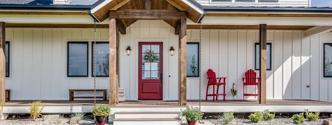 Black trim windows and red front door on white house. How to Find the Best Homeowners Insurance in Prairie Village, Kansas.