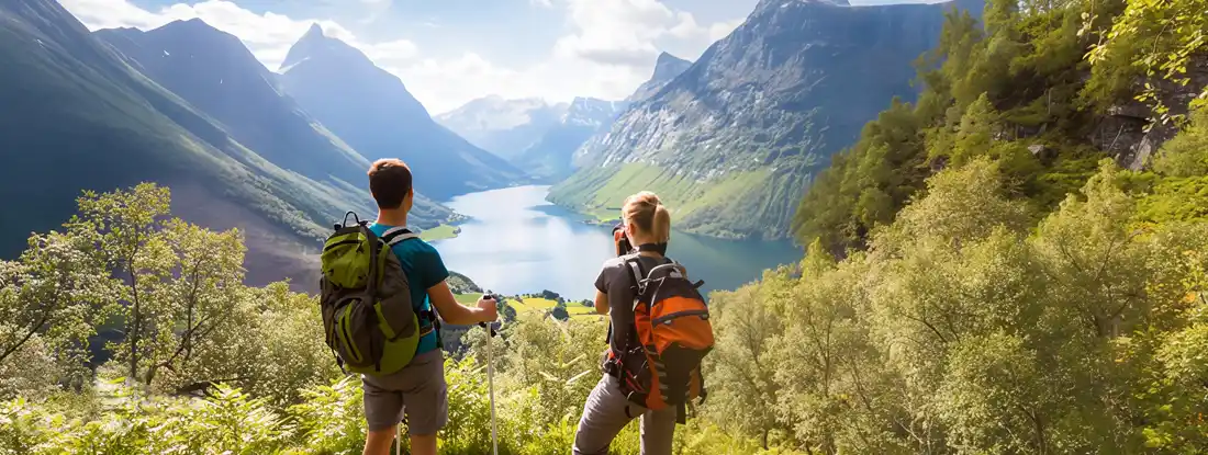 Two hikers at viewpoint in mountains with lake, sunny summer.  Find cheap life insurance.