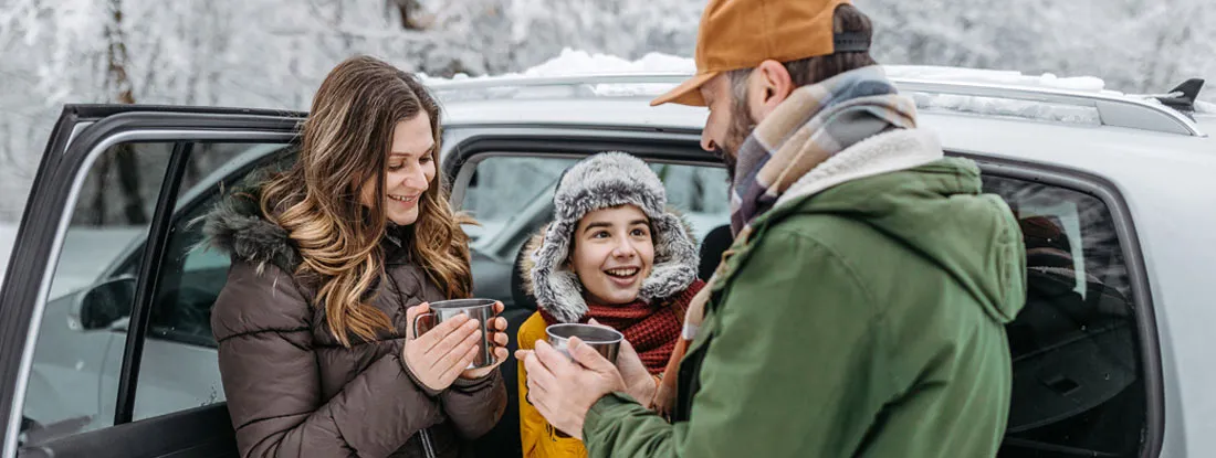 Family taking a break during a winter road trip. Find Juneau Alaska Car Insurance.