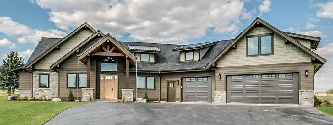 Large asphalt driveway leading to home with shades of brown and natural wood. How to Find the Best Homeowners Insurance Coverage in Joplin, Missouri.