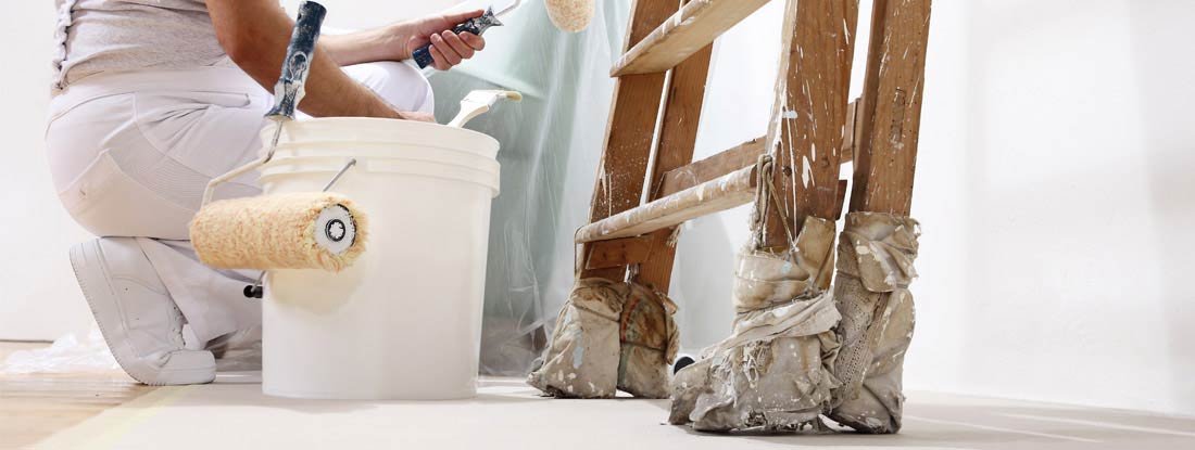 Painter painting a white wall. Find Painting Business Insurance.