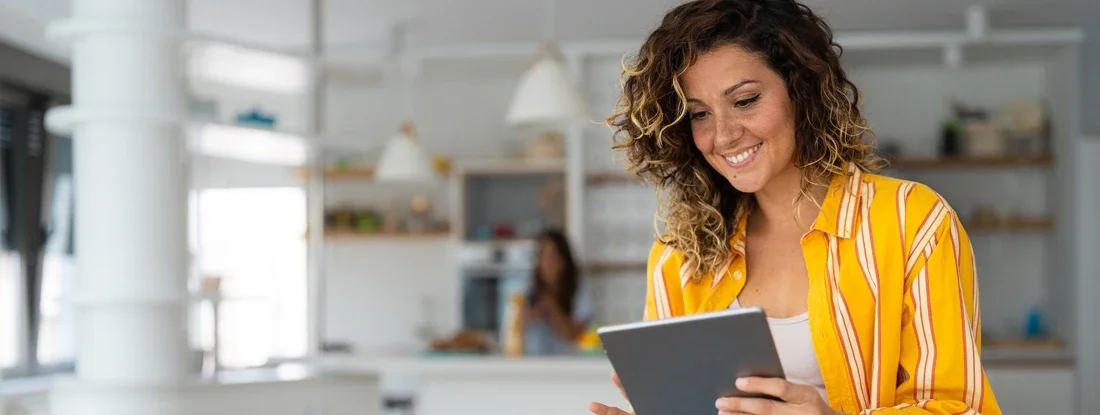 Businesswoman looking at tablet screen distantly working from home. Find Self-Employed Insurance.