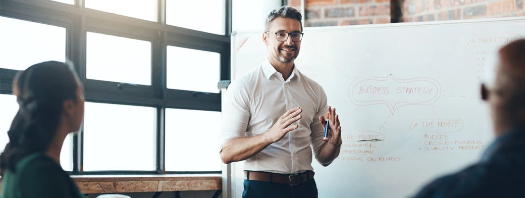 Business Consultant giving a presentation to a new business in boardroom