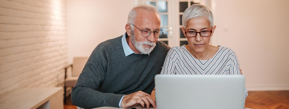 Senior couple researching long term care insurance taxes together. Long term care insurance tax deductions.