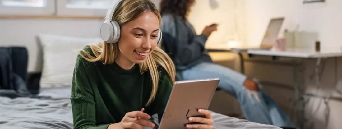 Female student using digital tablet in dorm room. Find Dorm and Homeowners Insurance.