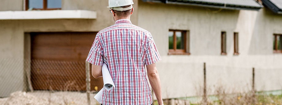 construction worker carrying blueprints