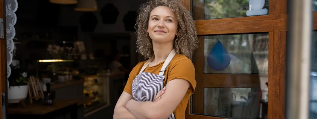 Waitress in apron standing outside of cafe and looking around. How to Find the Best Business Insurance in Thompson's Station, Tennessee. 